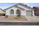 Charming single-story home featuring a two-car garage, arched windows, and neat desert landscaping at 1881 E Kerby Farms Rd, Chandler, AZ 85249