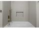 Modern white tiled shower showcasing gold hardware and built-in niche at 1881 E Kerby Farms Rd, Chandler, AZ 85249