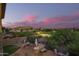 Elevated view of a backyard with a lush lawn, patio with a fire pit, and desert landscaping at 1935 E Seminole Dr, Phoenix, AZ 85022