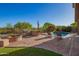 Inviting backyard with a pool, outdoor kitchen, manicured landscaping, and a brick patio at 1935 E Seminole Dr, Phoenix, AZ 85022