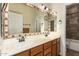 Bathroom featuring a double vanity with neutral countertops, wood cabinets, and tiled mirror at 1935 E Seminole Dr, Phoenix, AZ 85022