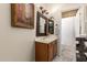 A bathroom vanity with a decorative mirror, warm lighting, and neutral paint at 1935 E Seminole Dr, Phoenix, AZ 85022