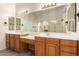 Bathroom featuring wood cabinets, a large mirror, dual sinks and granite countertops at 1935 E Seminole Dr, Phoenix, AZ 85022