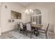 Bright dining room with a modern chandelier, neutral decor, and a large window with plantation shutters at 1935 E Seminole Dr, Phoenix, AZ 85022