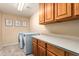 Efficient laundry room with modern appliances and functional storage and counter space at 1935 E Seminole Dr, Phoenix, AZ 85022