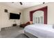 Well-lit primary bedroom features soft colors, a large bed and a big-screen TV at 1935 E Seminole Dr, Phoenix, AZ 85022