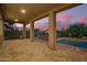 A spacious covered patio with brick flooring, offering views of the pool, and beautiful desert landscaping at 1935 E Seminole Dr, Phoenix, AZ 85022