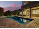 Tranquil backyard pool with brick surround, covered patio, and desert plants, ideal for relaxation at 1935 E Seminole Dr, Phoenix, AZ 85022