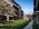 Modern condos with balconies overlook a manicured green lawn and walkway lined with blooming flowers and lush greenery at 19360 N 73Rd St # 1069, Scottsdale, AZ 85255