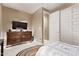Cozy bedroom features a rustic wood dresser with television and access to closet at 226 E Monza Way, San Tan Valley, AZ 85140