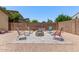 Spacious backyard patio features gravel, outdoor firepit, and comfortable seating for guests at 226 E Monza Way, San Tan Valley, AZ 85140