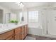 Bathroom with double vanity, soaking tub, glass-enclosed shower and plenty of natural light at 29007 N 120Th Dr, Peoria, AZ 85383