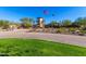 View of the clubhouse entrance featuring an expansive paved drive, well maintained landscaping, and American flag at 29007 N 120Th Dr, Peoria, AZ 85383