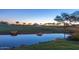 Picturesque golf course featuring a pond, lush green grass, and scattered trees at 29007 N 120Th Dr, Peoria, AZ 85383