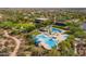 An aerial view of the community resort-style pool featuring a water slide, seating, lounge chairs, and umbrellas at 29007 N 120Th Dr, Peoria, AZ 85383