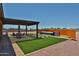Expansive backyard with artificial turf, hot tub, and covered patio perfect for relaxing and outdoor living at 29408 N 224Th Dr, Wittmann, AZ 85361