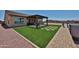 Expansive backyard with artificial turf, hot tub, and covered patio perfect for relaxing and outdoor living at 29408 N 224Th Dr, Wittmann, AZ 85361