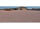 Wide view of the gravel-covered backyard and covered patio with pergola at 29408 N 224Th Dr, Wittmann, AZ 85361