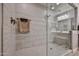 Walk-in shower featuring glass doors, showerhead, towel rack and tiled walls at 29408 N 224Th Dr, Wittmann, AZ 85361