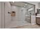 Walk-in shower featuring glass doors, showerhead, towel rack and tiled walls at 29408 N 224Th Dr, Wittmann, AZ 85361