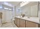 Bathroom with double sink vanity, large mirror, and a shower with a bathtub at 29408 N 224Th Dr, Wittmann, AZ 85361