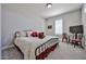 Cozy bedroom with a wrought iron bed frame, neutral walls, and a plush carpet at 29408 N 224Th Dr, Wittmann, AZ 85361
