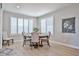 Light-filled dining room with elegant table, wood floors, and large windows with plantation shutters at 29408 N 224Th Dr, Wittmann, AZ 85361