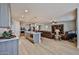 Spacious kitchen with island that flows into a living area and light wood plank floors at 29408 N 224Th Dr, Wittmann, AZ 85361