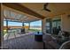 Relaxing covered patio with lounge seating, dining table, ceiling fan, and synthetic grass area at 29408 N 224Th Dr, Wittmann, AZ 85361