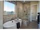 Elegant bathroom with a soaking tub and a beautifully tiled walk-in shower, perfect for relaxation at 37795 W Padilla St, Maricopa, AZ 85138