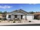 Charming single-story home featuring desert landscaping, gray accents, and a cozy front porch with seating at 37795 W Padilla St, Maricopa, AZ 85138