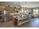Open-concept kitchen with a large island, stainless steel appliances, and views into the dining area at 37795 W Padilla St, Maricopa, AZ 85138
