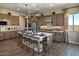 Modern kitchen boasts an island with seating, stainless steel appliances, and beautiful wood-look flooring at 37795 W Padilla St, Maricopa, AZ 85138