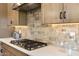 Close-up of a kitchen cooktop with stylish backsplash, stainless steel appliances, and ample countertop space at 37795 W Padilla St, Maricopa, AZ 85138