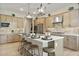 Bright kitchen features an island with seating, stainless steel appliances, and stylish pendant lighting at 37795 W Padilla St, Maricopa, AZ 85138