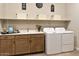 Well-organized laundry room featuring modern washer and dryer, counter space, and ample storage shelves at 37795 W Padilla St, Maricopa, AZ 85138