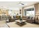 A spacious living room offers a large leather sectional sofa, ceiling fan, and an open floor plan at 37795 W Padilla St, Maricopa, AZ 85138