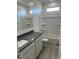 Bathroom with a granite countertop, large mirror, and a shower-tub combination with a window at 38105 W Bello Ln, Maricopa, AZ 85138