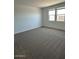 Neutral bedroom showcasing two windows and plush carpet flooring at 38105 W Bello Ln, Maricopa, AZ 85138