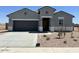 A charming single-story home with a gray exterior, a two-car garage, and well-maintained landscaping at 38105 W Bello Ln, Maricopa, AZ 85138