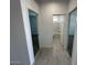 Bright hallway leading to bedrooms and bathrooms, with tile flooring and modern interior doors at 38105 W Bello Ln, Maricopa, AZ 85138
