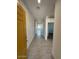 Hallway with neutral tile flooring and a view of the naturally lit open-concept living space at 38105 W Bello Ln, Maricopa, AZ 85138