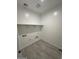 Functional laundry room with shelving, tile flooring, and utility connections for washer and dryer at 38105 W Bello Ln, Maricopa, AZ 85138