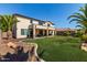 Expansive backyard with lush lawn, rock features, and a covered patio for outdoor living at 41448 N Eliana Dr, Queen Creek, AZ 85140