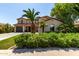 Inviting two-story home with a three-car garage and mature landscaping including palm trees at 41448 N Eliana Dr, Queen Creek, AZ 85140