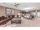 Open-concept living room with a ceiling fan seamlessly connects to the kitchen and dining area at 41448 N Eliana Dr, Queen Creek, AZ 85140