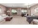 Spacious living room with neutral carpet, chandelier, and two large windows offering ample natural light at 41448 N Eliana Dr, Queen Creek, AZ 85140