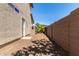 Clean side yard with neutral-toned stucco, potential gardening space, and access to the backyard through a gate at 41448 N Eliana Dr, Queen Creek, AZ 85140