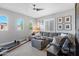 Bright living room featuring a large sofa, ceiling fan, dual windows, and exercise equipment at 4615 E Navigator Ln, Phoenix, AZ 85050