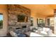 Outdoor living space with stone fireplace, TV, and comfortable seating at 4615 E Navigator Ln, Phoenix, AZ 85050